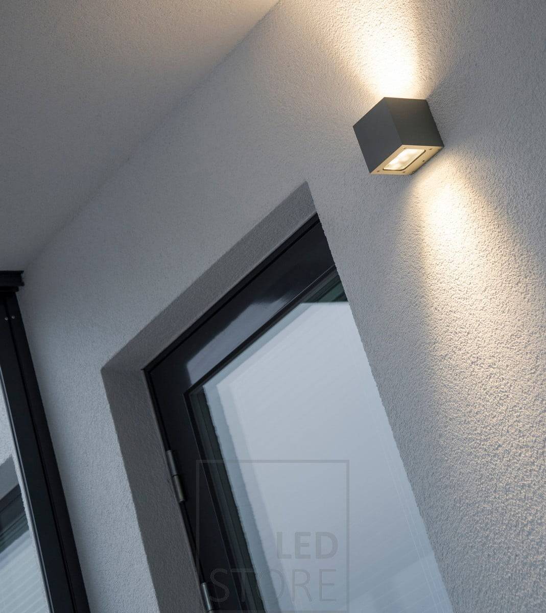 Obousměrné nástěnné světlo LED na fasádě domu. Svítidlo poskytuje atmosférické světlo přes stěnu a nepřímé světlo přes krytou terasu. Ledstore.fi